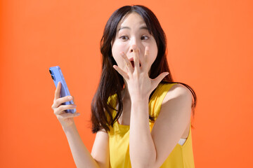 スマホを持って驚く女性