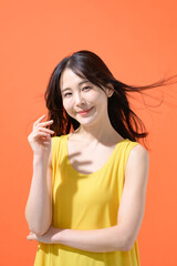 オレンジ背景　ミドル女性　ポートレート