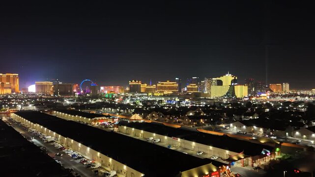Aerial video clip of the Las Vegas skyline at night, flying forward over business district rooftops