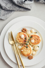 cottage cheese pancakes, syrniki, curd fritters served with pear balls, walnut and honey