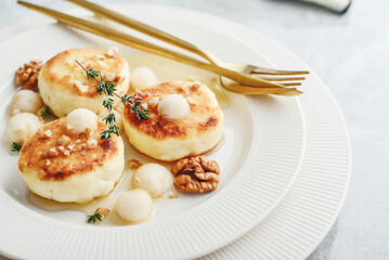 cottage cheese pancakes, syrniki, curd fritters with pear balls, walnut and honey