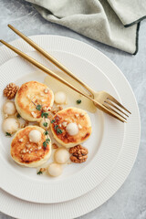 cottage cheese pancakes, syrniki, curd fritters with pear balls, walnut and honey