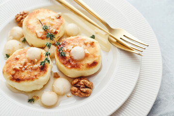 cottage cheese pancakes, syrniki, curd fritters with pear balls, walnut and honey