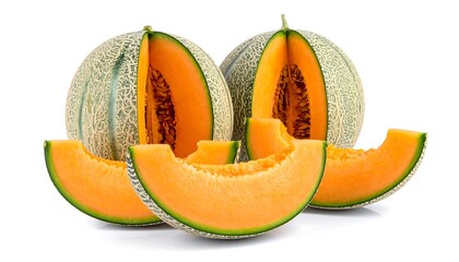 Close-up composition of several cantaloupe melons with one cut open, revealing bright orange flesh, and slices