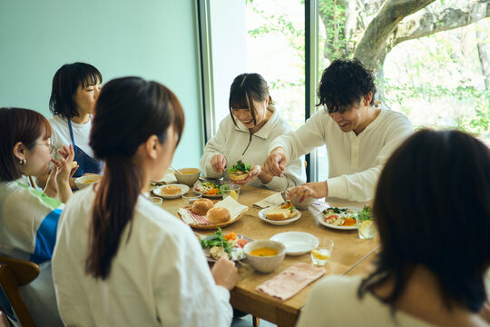 料理教室の後作った料理を囲んで食事を楽しむ人々