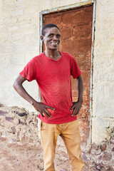 village happy african man portrait, outdoors in the nature ,stone wall with door behind