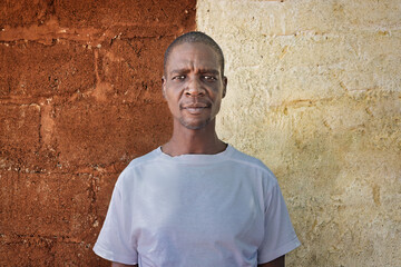 village happy african man portrait, outdoors in the nature ,stone wall with door behind