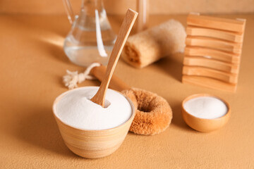 Bowls of baking soda with vinegar and cleaning supplies on orange grunge background, closeup