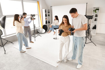Fototapeta premium Photographers with cameras during master class in studio