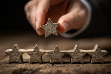 Hand arranging wooden stars for rating concept on wooden surface