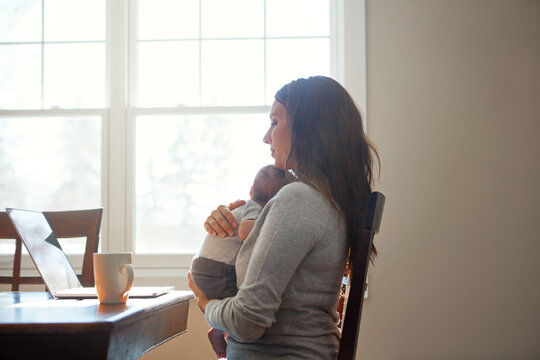 Remote work, newborn and mother with laptop in home for article review, bonding and multitasking. Freelance journalist, woman and love to infant for connection, time management or editing with space - Powered by Adobe