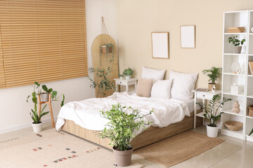 Obraz premium Interior of stylish bedroom with cozy bed, bedside table and houseplants