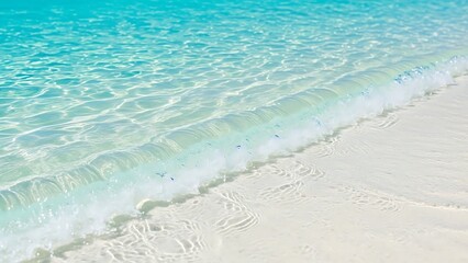 Obraz premium Crystal clear turquoise ocean water gently washes onto a pristine white sandy beach, creating a serene and inviting tropical paradise scene. Perfect for relaxation and travel themes.