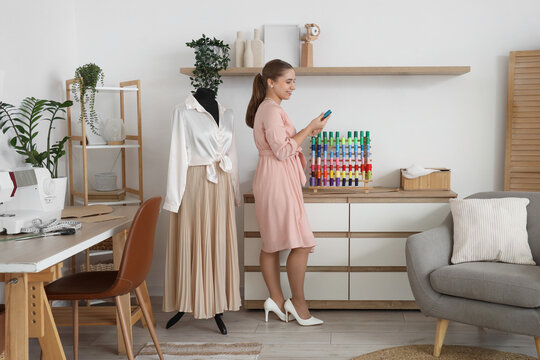 Female tailor with thread spools in atelier