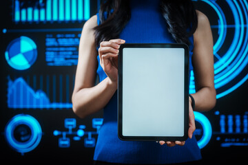 Woman holding tablet computer with futuristic blue data dashboard background, digital analytics, smart technology, data visualization, business intelligence, advanced user interface design.