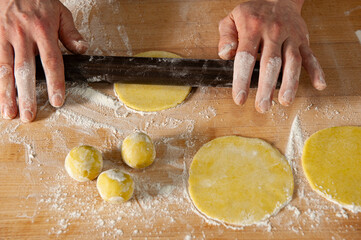 Professional baker shaping fresh dough by hand for traditional artisan bread