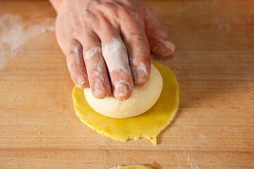 Professional baker shaping fresh dough by hand for traditional artisan bread
