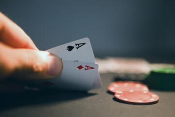 close up view of hand playing cards on table with casino chips. gambling concept