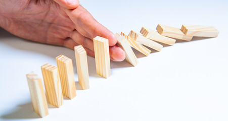Hand stopping domino effect on white background, business and risk concept