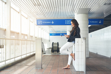 Happy, woman and reading with phone at station for travel, social media and transport schedule. Smile, female person and mobile for browsing website, online notification and texting at metro platform