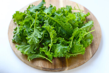 Fresh curly green kale leaves on white background.
