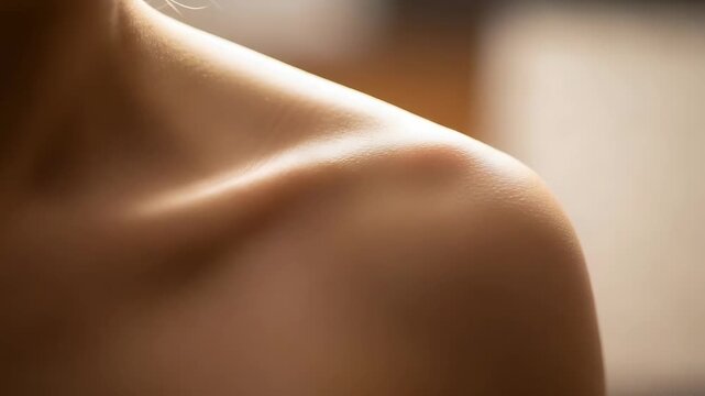 soft lit shoulder collarbone closeup with warm skin tones