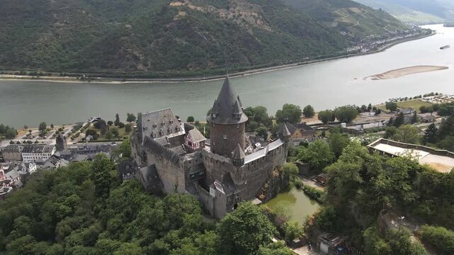 Drone shots of Bacharach castle in Germany with the Rhine River in the background.