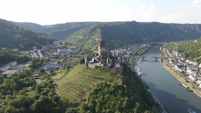 Drone shots of Reichsburg Cochem castle with the town and Moselle River in the background.