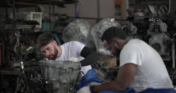 Auto mechanic disassemble mechanical engine components for diagnosis, troubleshooting in automotive workshop. Technical expertise, precision required in field of vehicle repair and maintenance.
