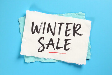 Winter Sale text on paper card on blue background