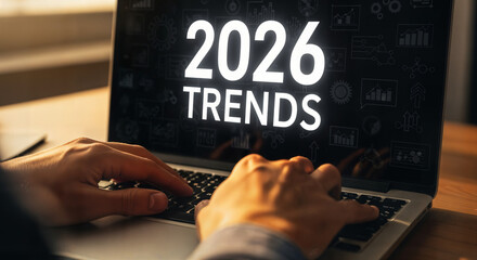 "Hands Typing on Laptop Keyboard with '2026 Trends' on Screen &mdash; Research and Market Analysis"
