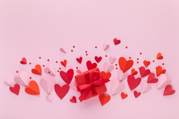 Saint Valentine day background with gift box decorated with red and pink craft hearts. Festive card for dating and romantic greeting.
