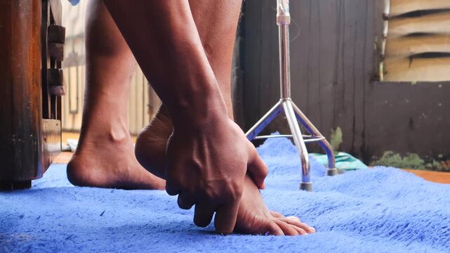 Foot pain, Asian man feeling pain in his feet at home, Man suffering from foot pain using hand massager relaxes the muscles of the soles of the feet, health problems and podiatry medical concept. 