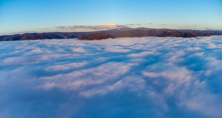 Fototapeta premium Landscape above the cloud layer. Aerial view above the sea of ​​clouds