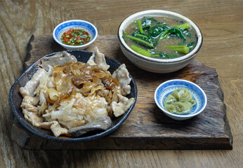 Wide rice noodles served Marinated pork and Chinese kale in a rich, thick gravy sauce (Rad Na Moo). The dish is accompanied by condiments of sliced chilies in fish sauce and pickled chili in vinegar, 