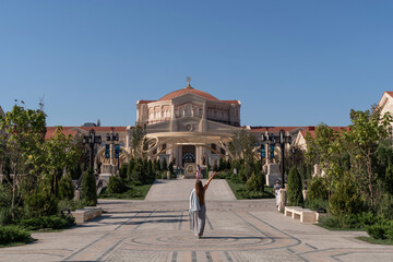 Woman, Church, Garden - Tourist taking a photo in front of a beautiful church in a garden setting.
