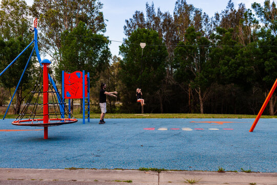Father playing at park with daughter on flying fox