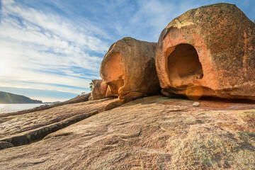 Large weathered rock formations covered in lichen, perched on a granite ledge