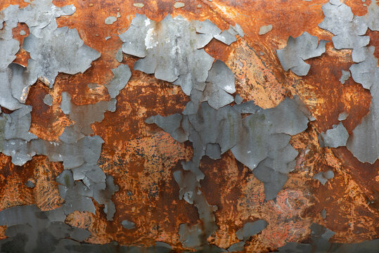 Flaking paint and rust on a water supply pipe.