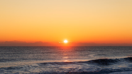 Sunrise Light Behind Low Clouds Over the Ocean