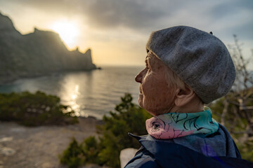 Senior woman profile view of elderly lady enjoying peaceful sunset on the sea coast.