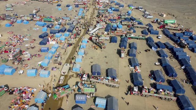 Torkham Refugee camp full of people arriving and going in trucks in mountains for Afghans who have come from Pakistan, Aerial drone, Afghanistan