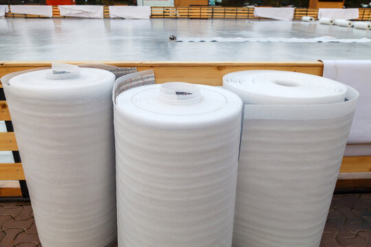 Three rolls of white polyethylene insulation film stand upright and are ready for use.