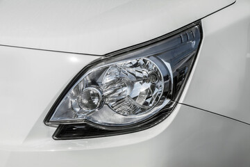 The headlight of a white car. The headlight is silver