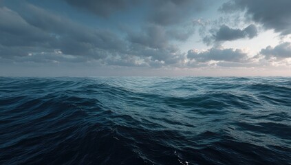 Turbulent, deep blue ocean waves under a dramatic, cloudy sky at sunset