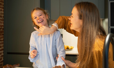 Mother and daughter bonding during baking activity in kitchen