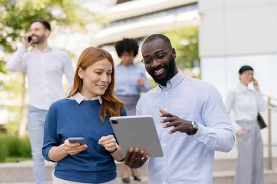 Business team having a conversation and making a video call on a tablet outdoors
