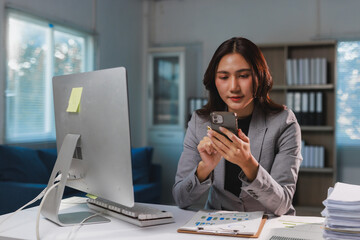 Young businesswoman using smartphone researching in modern office