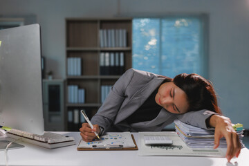 Tired businesswoman sleeping while working late at office desk