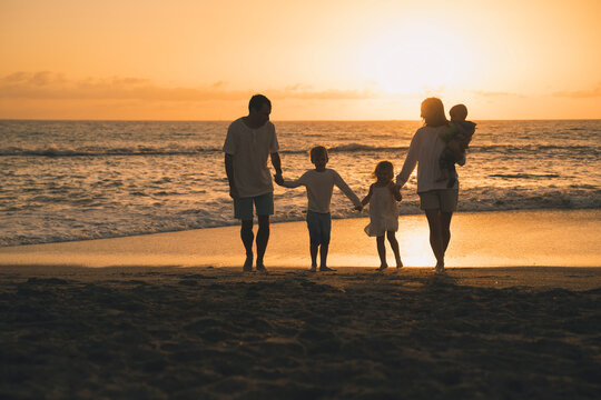 Family enjoying quality time together at beach during sunset